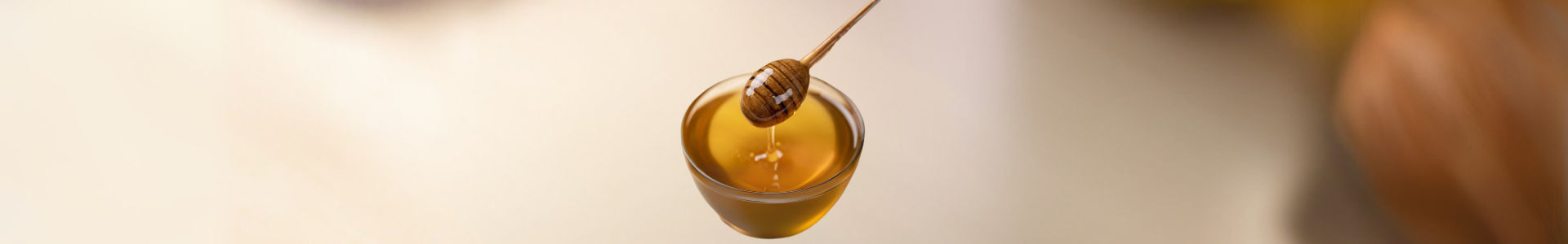Primrose honey dripping from a honey dipper, highlighting its natural sweetness and health benefits