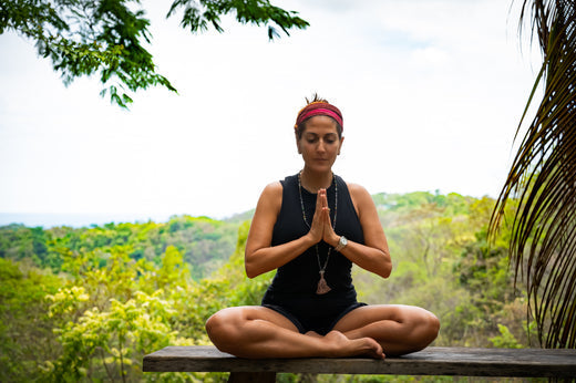 Woman practicing yoga in the mountains during travel