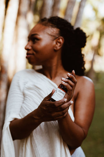 Woman holding Osi Oils Féminin Organic Ayurveda Breast Oil for self-love and breast massage ritual
