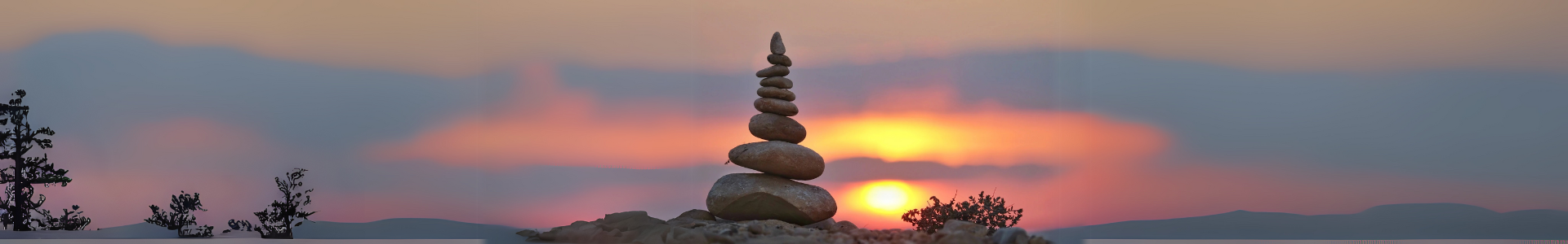 Stacked stones balanced at sunset symbolizing spiritual reflection and emotional grounding